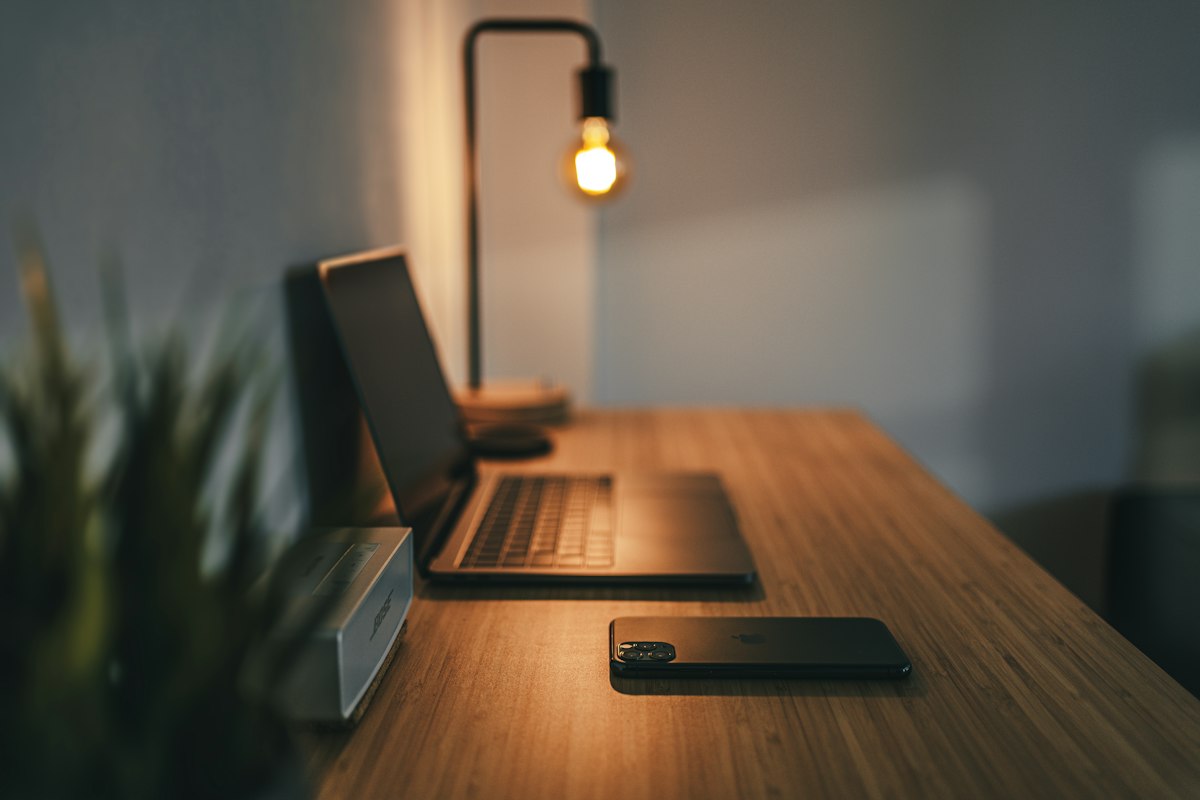 Clean minimalist desk with dual monitors and warm task bar illumination